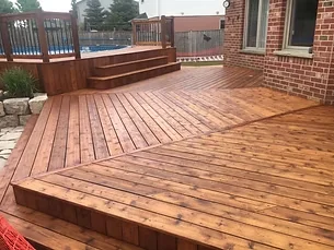 Finished warm brown stained deck with steps and wood railings