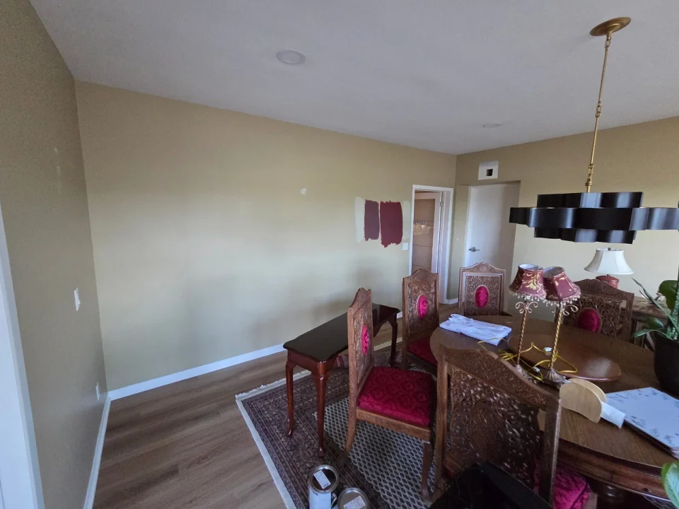 Before: pale dining room walls with colour samples beside a large window