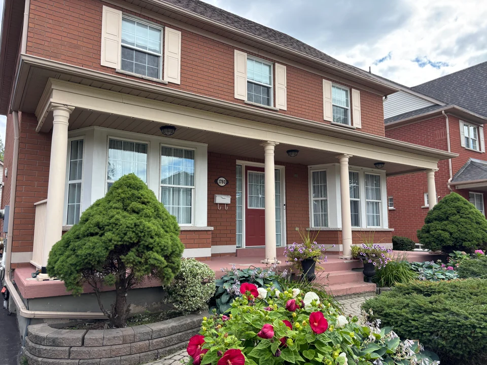 Angled view of white porch columns and trim on a red brick home