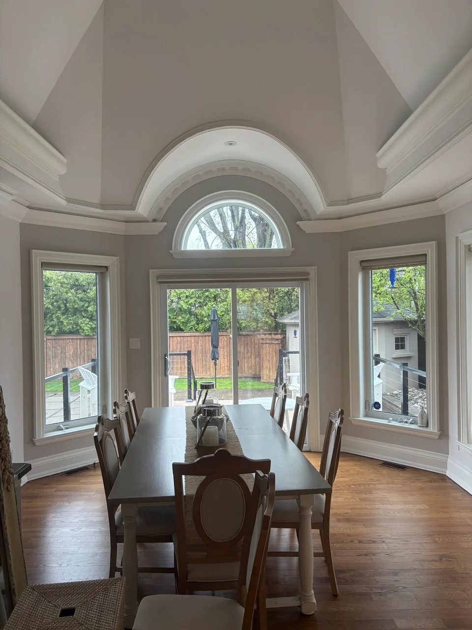Wide view of domed dining ceiling and white trim around garden windows