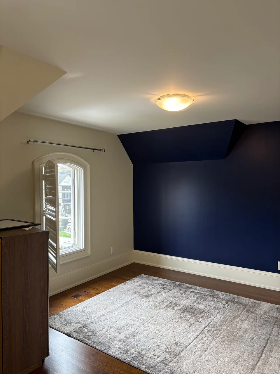 Finished navy bedroom feature wall beside an arched window