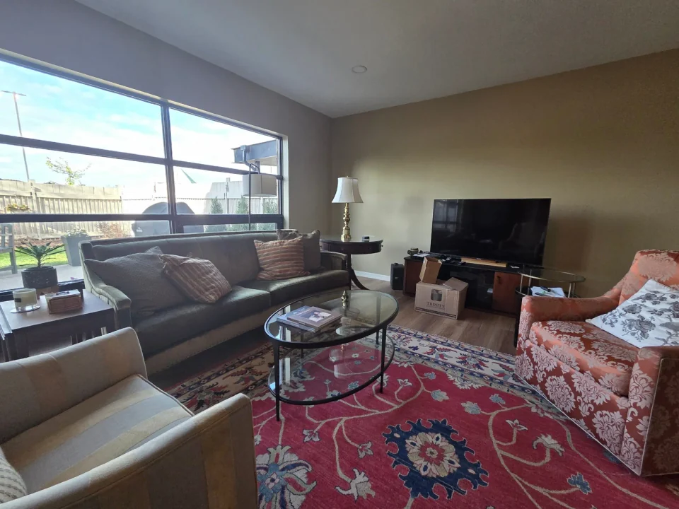 Finished living room with warm neutral walls and a large picture window
