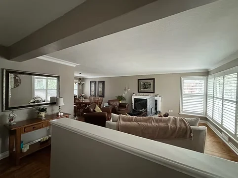 Finished light neutral living room walls around the fireplace and windows
