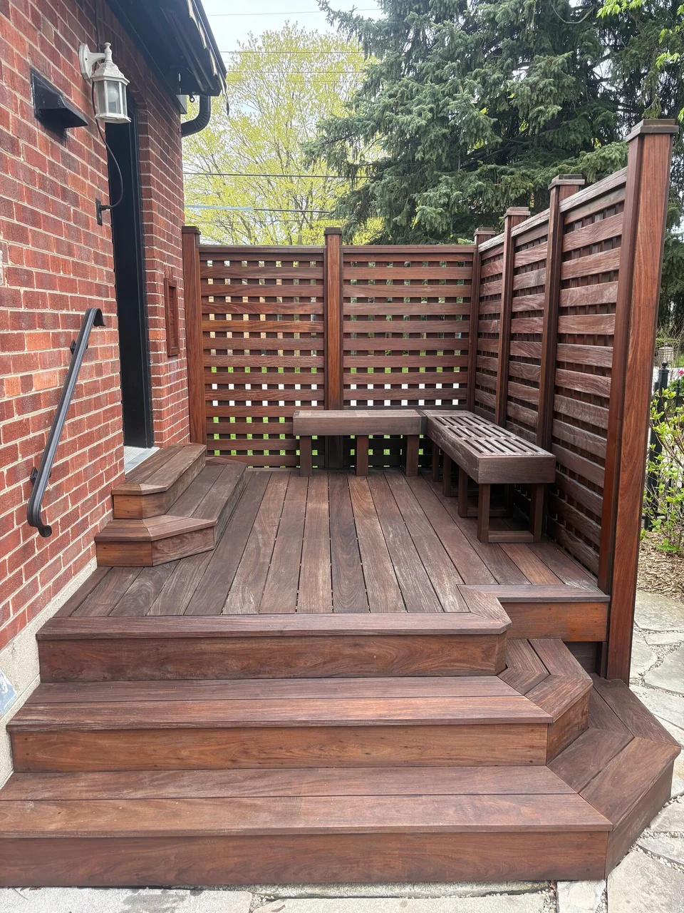 After: brown stained deck steps, built-in bench and privacy screen