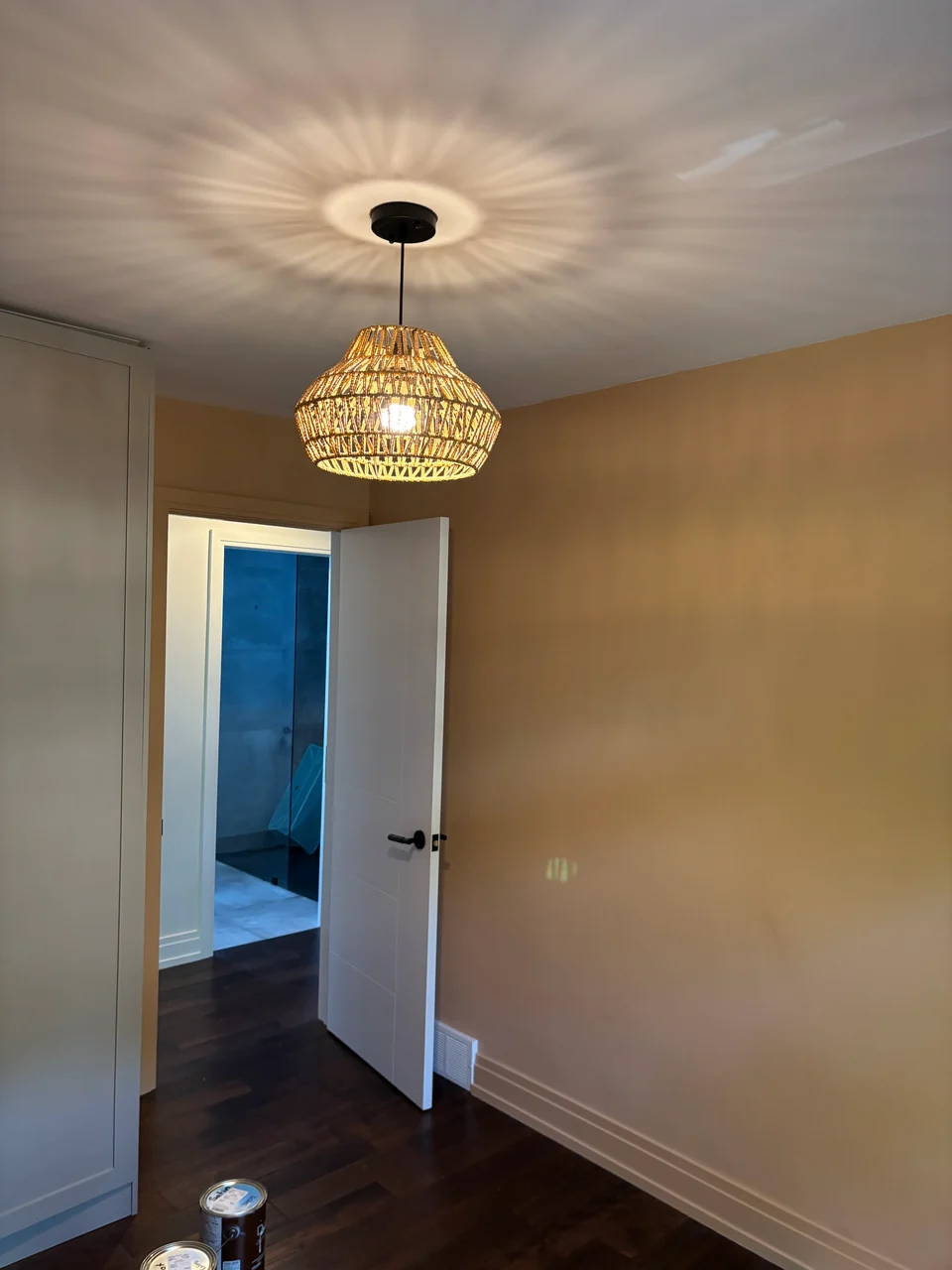 Before: warm beige room wall beneath a woven pendant light