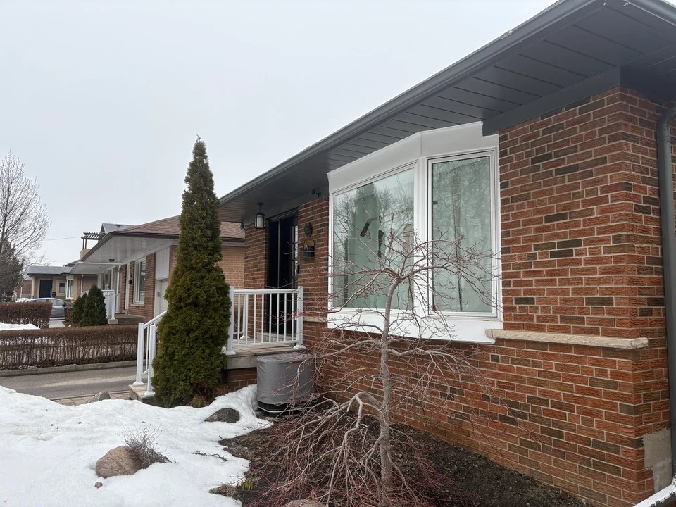 Before: grey front soffit and fascia on a brick bungalow in winter